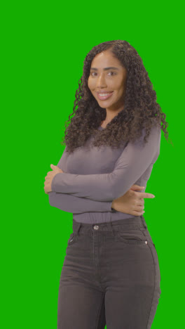 Vertical-Video-Three-Quarter-Length-Studio-Vertical-Video-Portrait-Of-Vertical-Video-Woman-Against-Green-Screen-Smiling-At-Camera